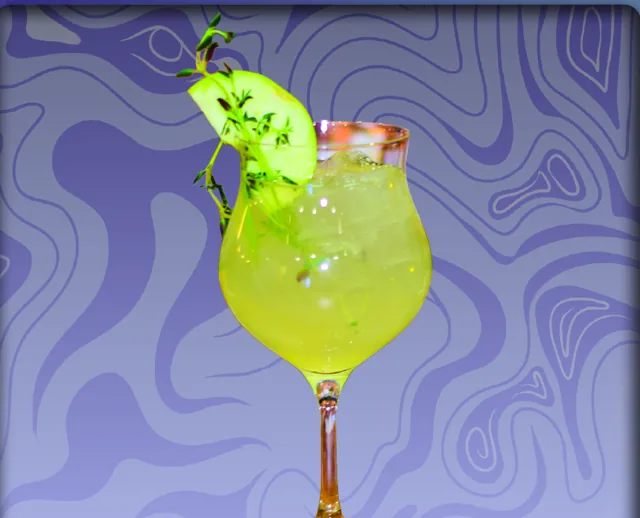 A Crisp Perspection: a bright green-gold cocktail over ice with an apple slice and thyme sprig