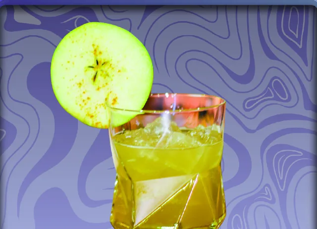 A New Perspection: a golden cocktail over ice in a rocks glass with an apple slice on the rim